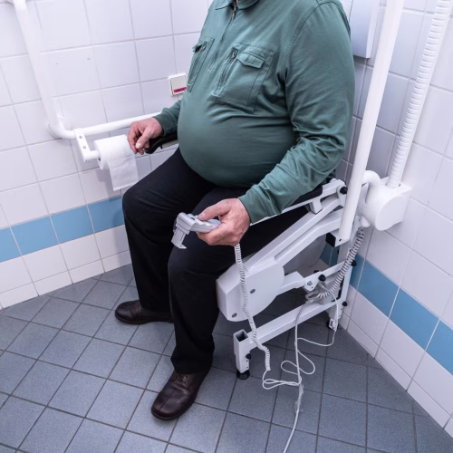 Herr nutzt die Aufstehhilfe R2Dfx zum sicheren und einfachen Aufstehen von der Toilette