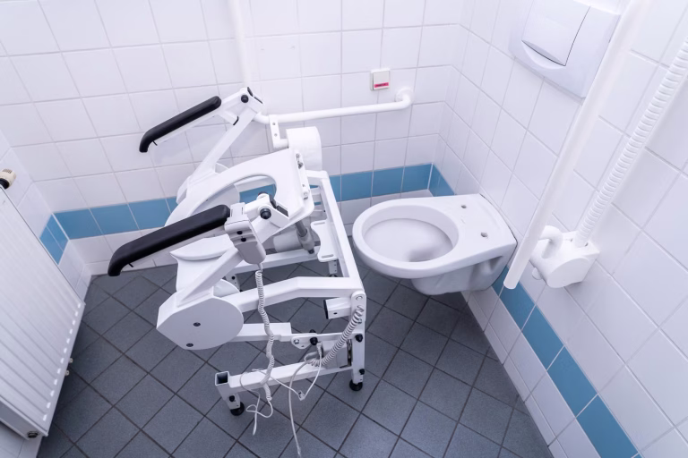 Weiße R2dfx WC-Aufstehhilfe die über das WC geschoben wird.